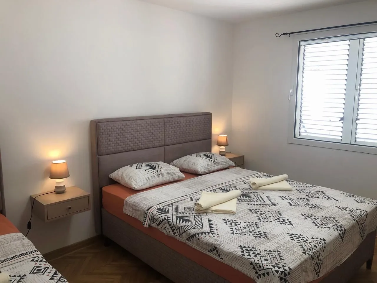 Bedroom with a double bed, bedside tables and a window.
