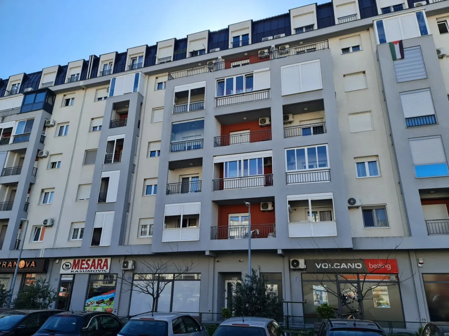 Facade of a modern residential building with commercial spaces on the ground floor.