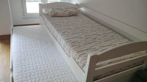White bed with a pull-out mattress in the bedroom. - image 10