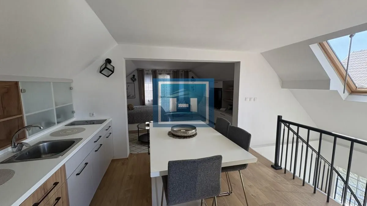 Kuhinja sa trpezarijom i pogledom na stepenište u potkrovlju.