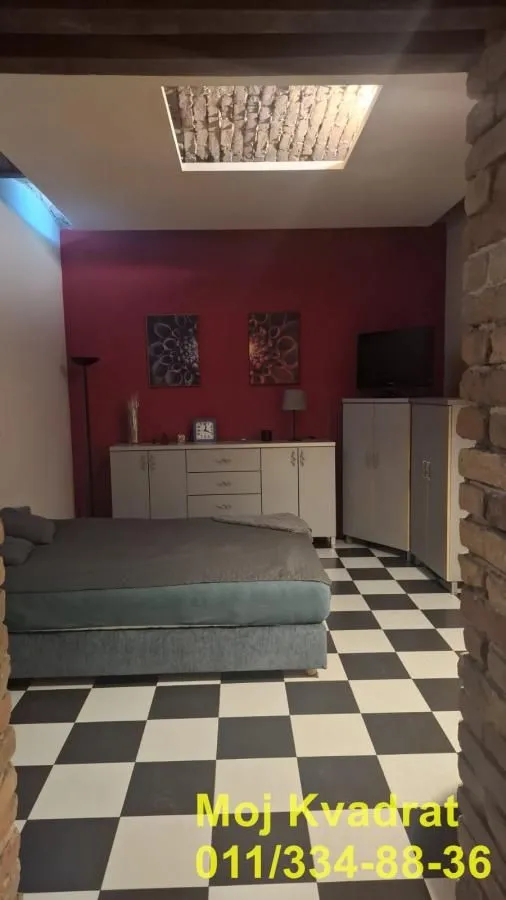 Bedroom with a bed, dresser, and a red wall.