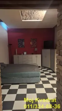 Bedroom with a bed, dresser, and a red wall. - image 2
