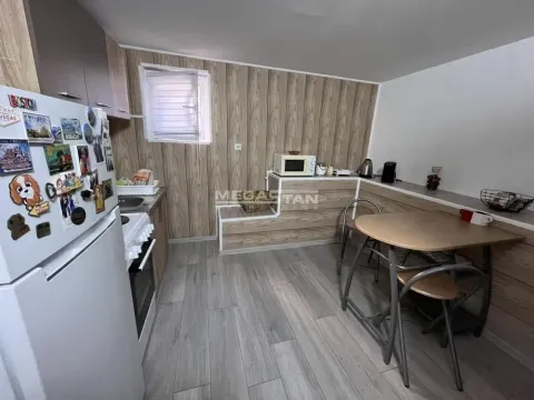 Kuhinja sa trpezarijskim delom i drvenim oblogama na zidu. - image 7