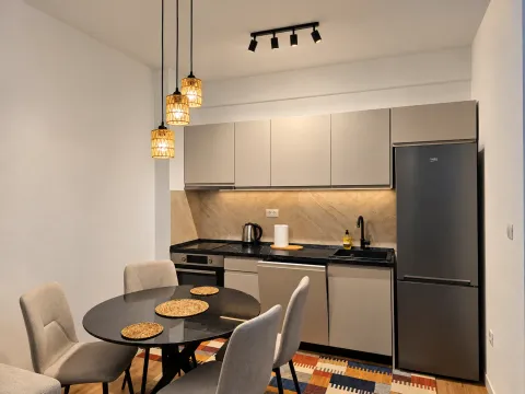 Modern kitchen with a dining table and built-in appliances. - image 6