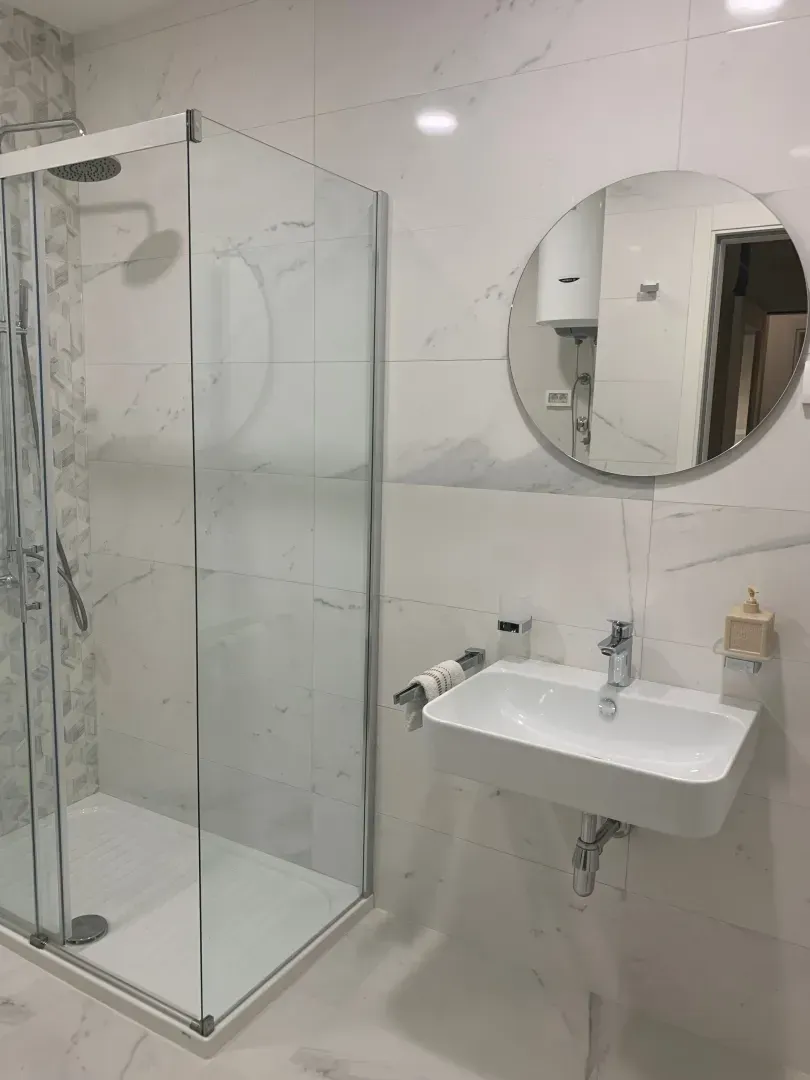 Moderne opremljeno kupatilo sa tuš kabinom i umivaonikom.