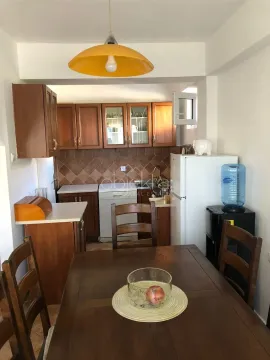 Kitchen with dining area equipped with wooden cabinets and appliances. - image 8