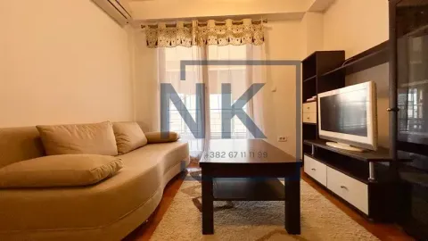 Living room with a sofa, coffee table, and television. - image 8