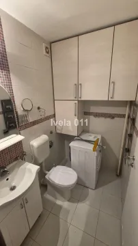 Kupatilo opremljeno sanitarijama, umivaonikom, veš mašinom i ugradnim ormarićima. - image 10