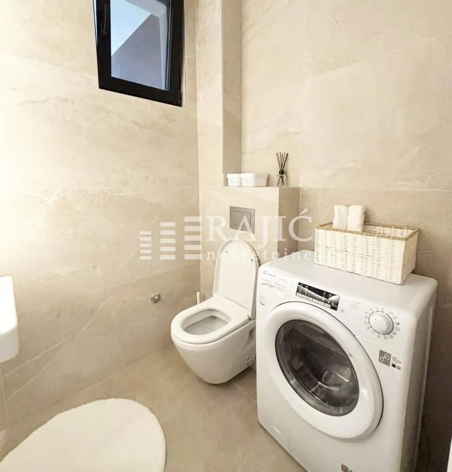 Small bathroom with a washing machine and a built-in toilet bowl.