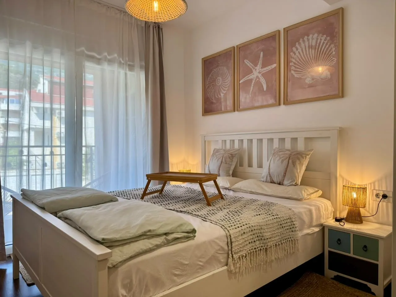 Furnished bedroom with a double bed, nightstand, and decorative wall art.
