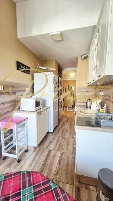 Small kitchen with white cabinets and wooden details.
