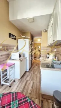 Small kitchen with white cabinets and wooden details. - image 6