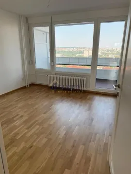 Prazna soba sa parketom i velikim prozorima koji gledaju na grad. - image 4
