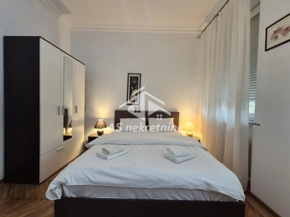 Furnished bedroom with a large double bed and a wardrobe.