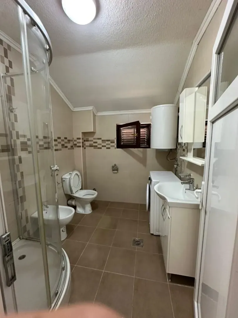 Bathroom equipped with a shower cabin, sanitary fixtures, and a washing machine.