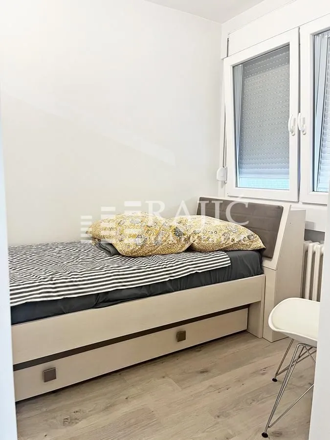 Small bedroom with a bed and a window.