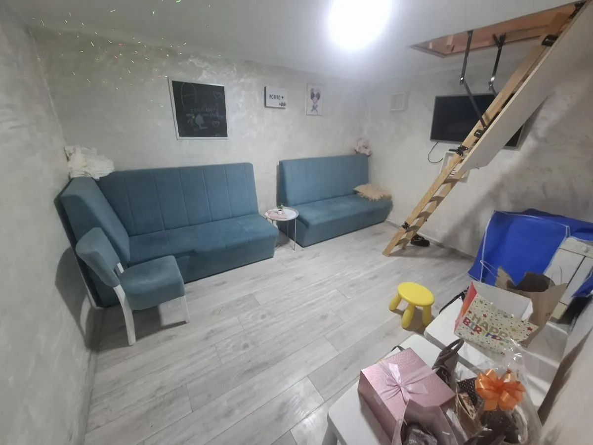 Living room with blue sofas and stairs leading to the attic.