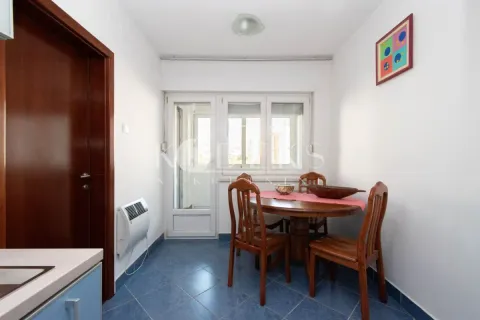 Dining area with a wooden table and chairs, blue floor tiles, and access to the terrace. - image 4