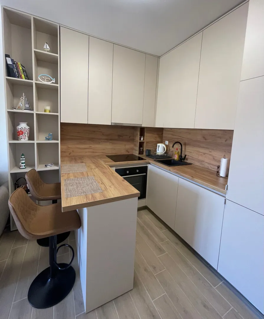 Modern kitchen with a bar counter and wooden elements.