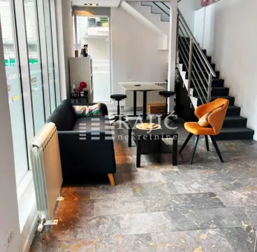 Living room with a sofa, dining table, and staircase. - image 6