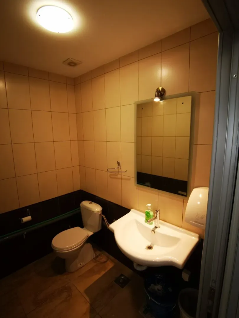 A small bathroom with a sink, mirror, and toilet.