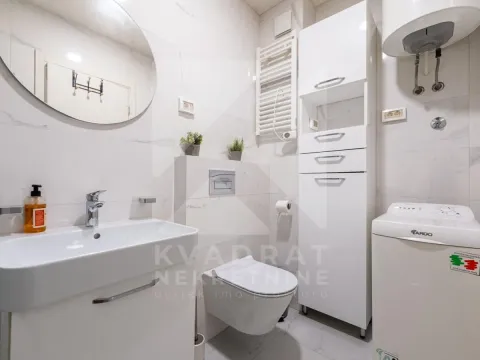 Kompaktno kupatilo sa bijelim namještajem, sanitarijama i veš mašinom. - image 7