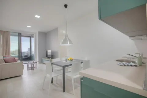 Modern kitchen with a dining area and living room in light tones. - image 5