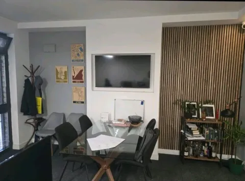 Living room with a dining table and a TV. - image 11