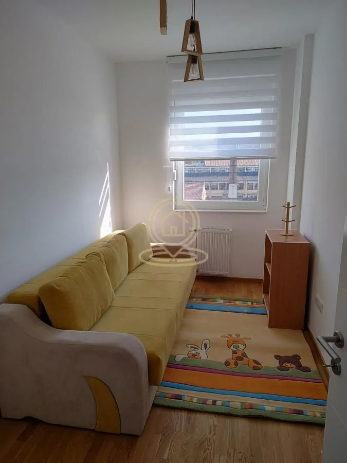 Dnevna soba sa kaučem i šarenim tepihom.