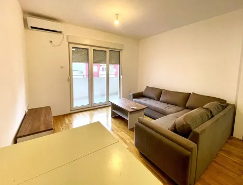 Dnevna soba sa ugaonom garniturom, stočićem i izlazom na terasu. - image 3