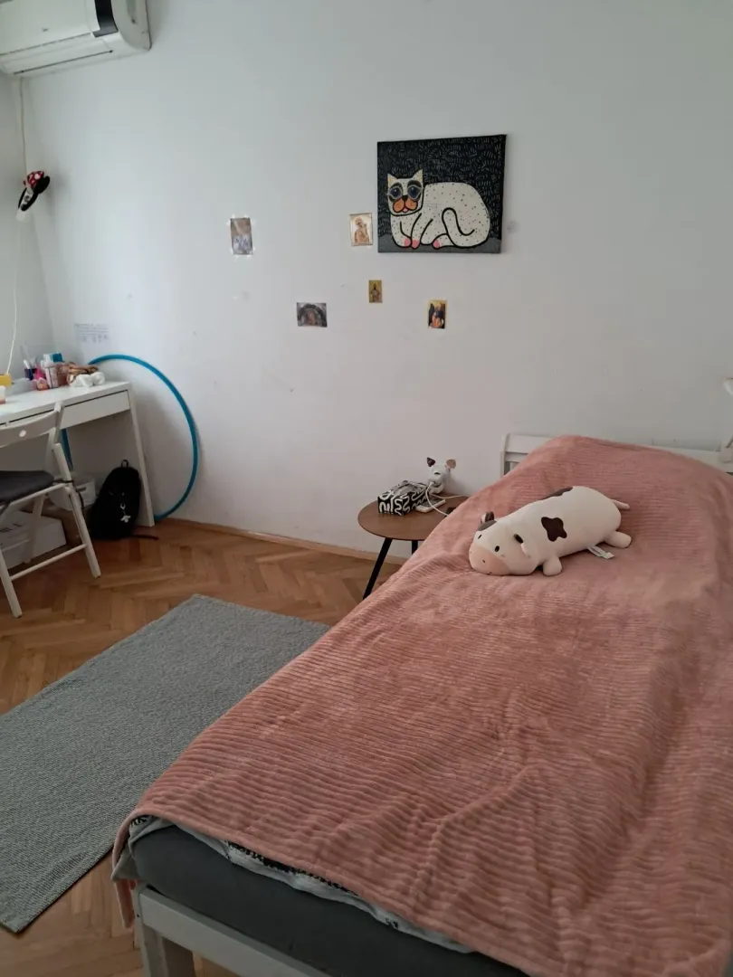 Nameštena spavaća soba sa krevetom i radnim stolom.
