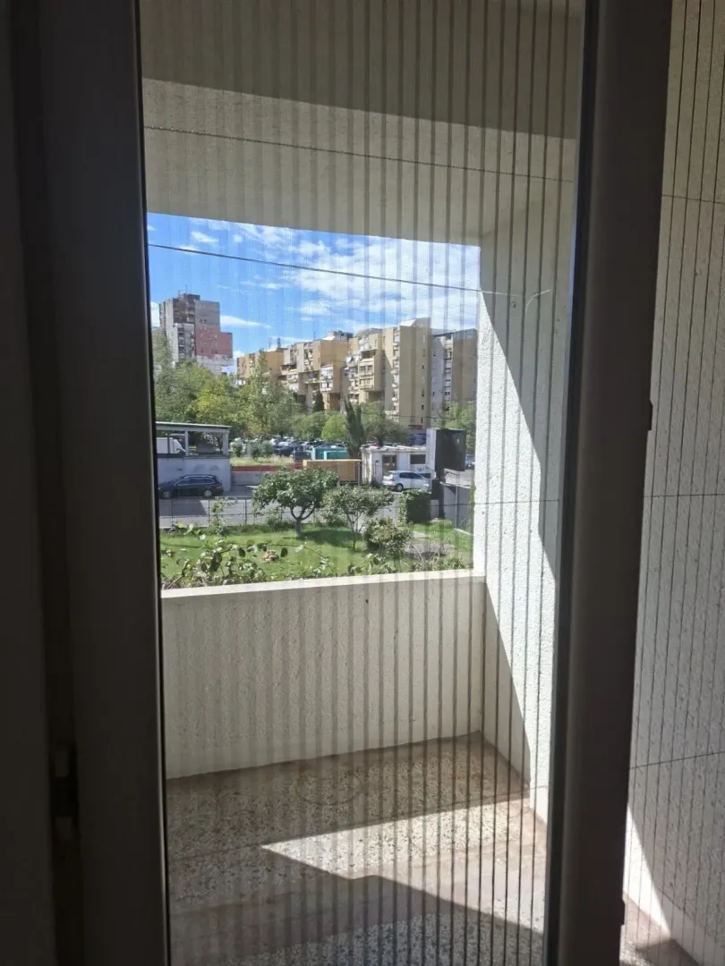 Pogled na balkon kroz vrata sa mrežicom.