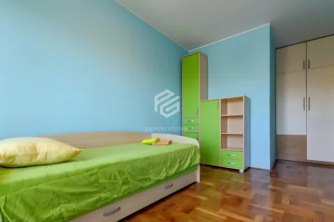 Dječija soba sa krevetom, plavim zidovima i ormarima u zelenim tonovima. - image 3