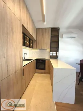 Modern kitchen with wooden cabinetry and light marble countertop. - image 9