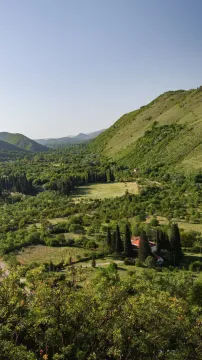 Pogled na zelenu dolinu, brda i kuću sa okućnicom. - image 2