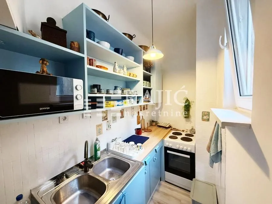Small kitchen with blue cabinets and built-in appliances.