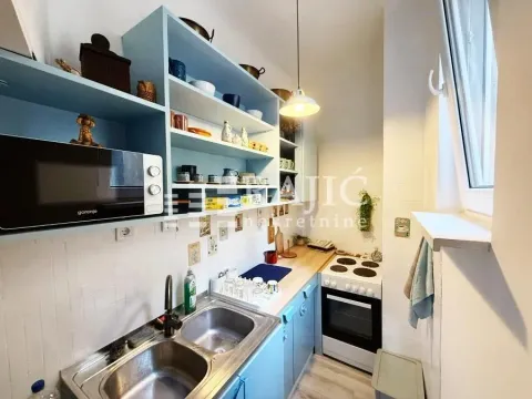 Small kitchen with blue cabinets and built-in appliances. - image 8
