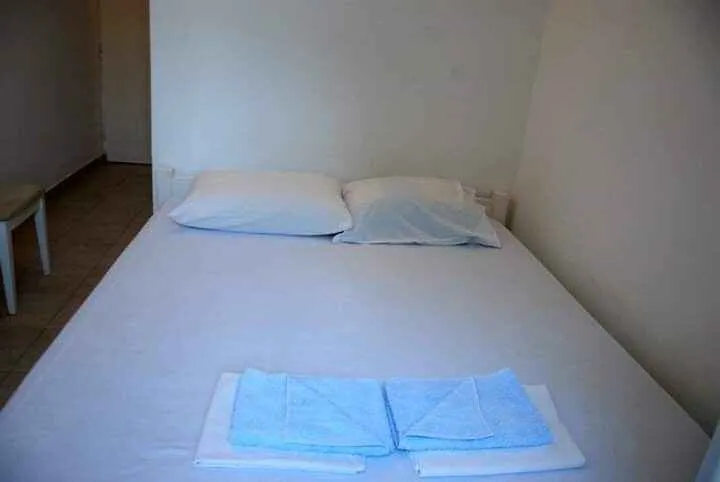 A simple double bed with prepared towels.