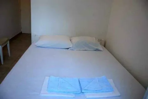 A simple double bed with prepared towels. - image 6