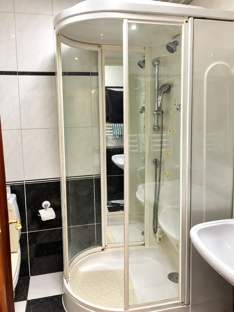 Pregled kupatila sa tuš kabinom i sanitarijama.