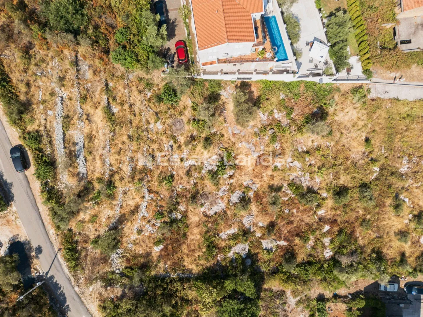 Pogled iz vazduha na plac sa kućom i bazenom.