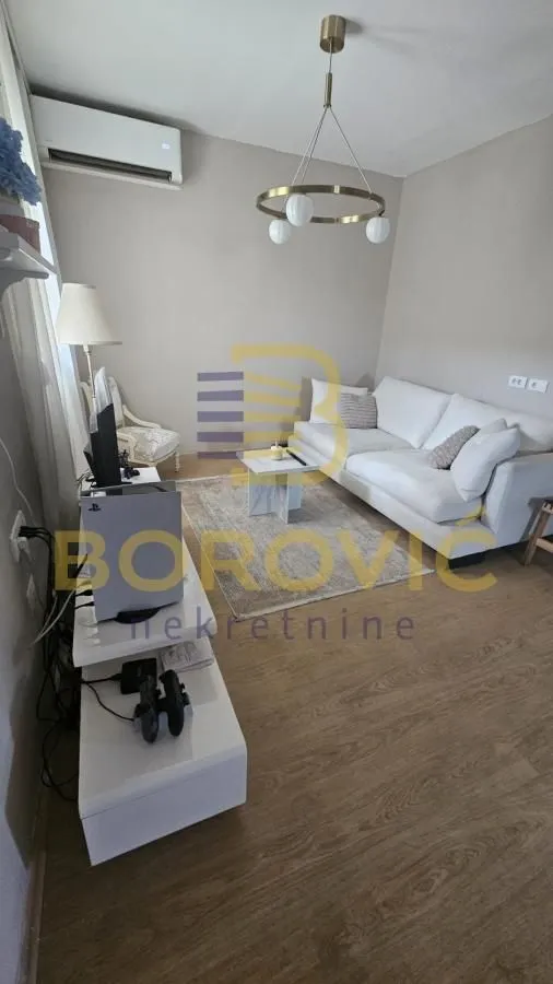 Living room with sofa, coffee table and TV unit.