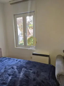 Manja spavaća soba sa krevetom i prozorom koji gleda na dvorište. - image 9