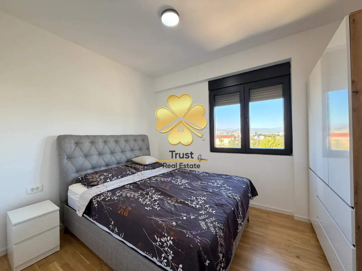 Furnished bedroom with a double bed and a window.