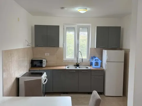 Kitchen with grey cabinets, sink, stove, and refrigerator. - image 4