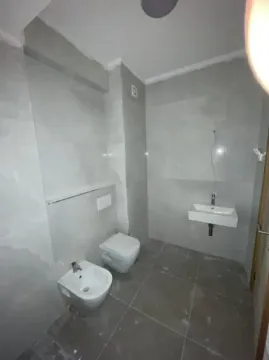 Novoopremljeno kupatilo sa sivu keramikom, umivaonikom i sanitarijama. - image 10