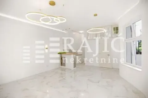 Bright living room with modern lighting and a kitchen in the background. - image 12