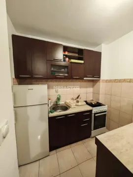 Manja kuhinja sa tamnim drvenim elementima i osnovnim kućnim aparatima. - image 6