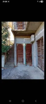 Eksterijer kuće sa spoljnim stepeništem i drvenim vratima. - image 3