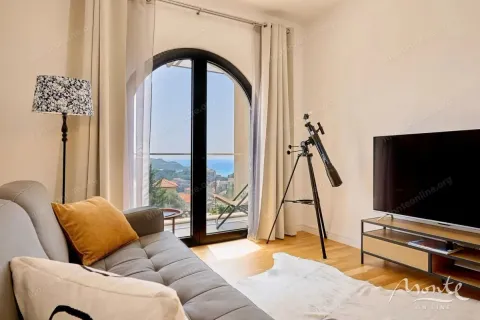Dnevna soba sa garniturom, televizorom i izlazom na terasu sa pogledom na more. - image 6